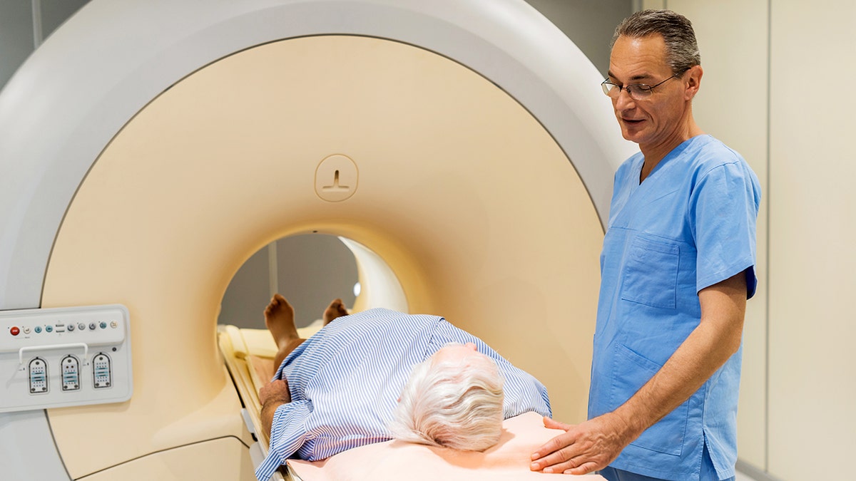 The male radiologist talks to a patient who is about to receive a medical examination for prostate cancer.