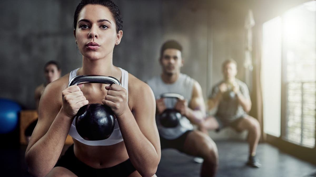 Shot a young woman in shape working with a boiling bell in the gym