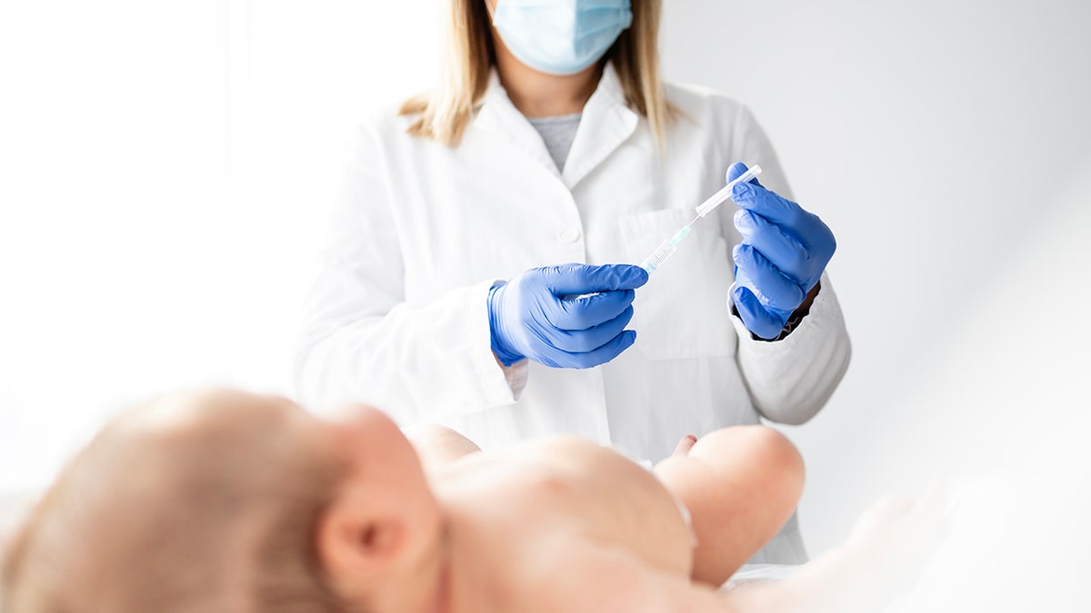 Pediatric Physician preparing the injection of the baby's vaccine