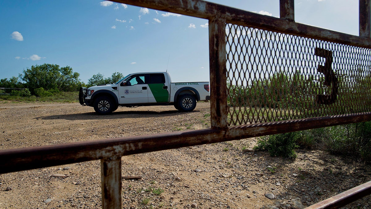 Border patrol agents behind the fence